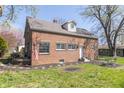 Rear exterior of a brick home featuring a well-maintained backyard, patio, and mature trees at 2741 Mars Hill St, Indianapolis, IN 46241