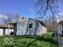 A side exterior shot of a house with simple design and a view of the green, sloping backyard at 2823 N Gladstone Ave, Indianapolis, IN 46218