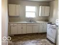 Functional kitchen featuring white cabinets, a standard sink, and a basic electric range at 2823 N Gladstone Ave, Indianapolis, IN 46218