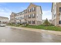 Street view of townhomes featuring landscaped lawns and sidewalks at 3527 Brampton Ln, Westfield, IN 46074