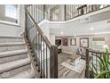 View of a staircase leading to a living room with wooden floors and sports decor at 3527 Brampton Ln, Westfield, IN 46074