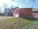 View of the home with an attached garage, large screened-in porch, and well-maintained lawn and landscaping at 359 N Jefferson St, Martinsville, IN 46151