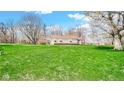 Expansive backyard showcasing the home's setting amidst mature trees and green lawn at 5196 N London Rd, Fairland, IN 46126