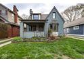 Lovely two-story home featuring a covered porch, bay window and a well-maintained yard at 5654 Broadway St, Indianapolis, IN 46220