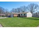 A well-maintained single-story home featuring a spacious lawn and mature trees at 617 Kokomo Ln, Indianapolis, IN 46241