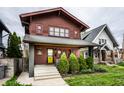 Inviting craftsman home with a yellow door, mature landscaping, and classic architectural design at 622 E 37Th St, Indianapolis, IN 46205