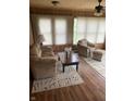 Cozy living room features wood-paneled walls, neutral furniture, and natural light, creating a warm and inviting space at 6389 N Forest St, Martinsville, IN 46151