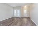 Open living area with wood floors, neutral paint, and access to a balcony at 6585 Reserve Dr, Indianapolis, IN 46220