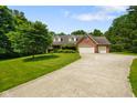 A charming brick home with an attached two-car garage and a lush green lawn at 6761 E Woodland Ct, Mooresville, IN 46158
