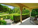 Relaxing covered porch with comfortable seating and a view of the landscaped yard at 6761 E Woodland Ct, Mooresville, IN 46158