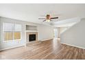 Bright living room with hardwood floors, a ceiling fan, and a cozy fireplace at 693 Cembra Dr, Greenwood, IN 46143