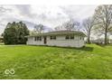 A quaint single-story home with a neat front yard, showcasing its simple yet inviting facade and attached garage at 7144 Lockwood Ln, Indianapolis, IN 46217