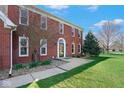 Traditional two-story brick home with a covered front entrance and landscaped front yard at 7265 Derbyshire Dr, Cumberland, IN 46229