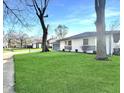 Charming single-story home with a large yard, white painted brick, and a grey two-car garage at 7606 Miracle Rd, Indianapolis, IN 46237
