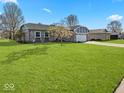 Lush green lawn surrounds this single-story home with a two-car garage and brick facade at 919 Oak Park Dr, Shelbyville, IN 46176