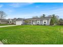 Charming single-story home with a well-manicured lawn and attached two-car garage at 9328 Haddington W Dr, Indianapolis, IN 46256