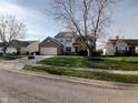 Residential property with brick and siding exterior, green lawn, mature trees, and visible mailbox near the street at 10629 Simsbury Ct, Indianapolis, IN 46236