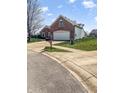 Lovely brick home featuring a well-manicured lawn and a paved driveway at 11631 Tucker Ct, Indianapolis, IN 46229