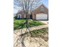 Well-maintained lawn and landscaping enhance the curb appeal of this brick home at 11631 Tucker Ct, Indianapolis, IN 46229