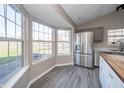 Bright dining area featuring a stainless steel refrigerator, a garden view, and modern flooring at 1231 Chesterfield Dr, Anderson, IN 46012