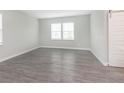 Bright, spacious bedroom with wood-look flooring, two windows, and a sliding barn door at 1268 Newton St, Avon, IN 46123