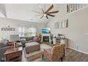 Comfortable living room featuring vaulted ceiling, large fan, fireplace, and modern furnishings at 13351 Grosbeak Ct, Carmel, IN 46033