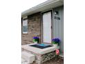 Close-up of the front porch, showcasing a welcoming door mat and decorative floral arrangements at 2126 Dawnshire Dr, Columbus, IN 47203