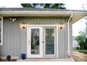 Exterior view of sliding glass doors with outdoor lighting and gray siding at 2126 Dawnshire Dr, Columbus, IN 47203