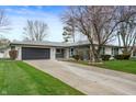 Charming ranch-style home with a stone facade, well-maintained lawn, and gray garage doors at 2200 W Christy Ln, Muncie, IN 47304