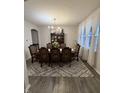 Formal dining room with elegant wood table, chairs, decorative rug, and natural light from large window at 280 Walker Dr, Whiteland, IN 46184