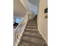 Carpeted staircase with white railing, connecting different levels of a home with views of the living area at 280 Walker Dr, Whiteland, IN 46184