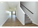 Open entryway with stairs, shiplap accent wall, and view into a spacious living area at 321 Bluestem Ln, Whiteland, IN 46184