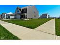 Suburban two-story home with lush green lawn, sidewalk, and beautiful landscaping at 321 Bluestem Ln, Whiteland, IN 46184
