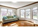 Bright living room featuring hardwood floors, large windows, and a comfortable green couch with pillows at 3634 W 58Th St, Indianapolis, IN 46228