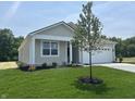 Single story home with a well-maintained lawn, complimented by a young tree and neutral siding at 3915 Donaldson Creek Ct, Clayton, IN 46118