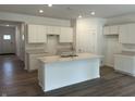 Modern kitchen featuring white cabinets, a central island, and hardwood floors at 3915 Donaldson Creek Ct, Clayton, IN 46118