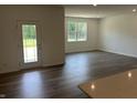 Bright, open-concept living room with hardwood flooring, a glass door and natural light at 3915 Donaldson Creek Ct, Clayton, IN 46118
