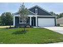 Charming home featuring blue siding, white trim, a spacious driveway, and a two-car garage at 3933 Donaldson Creek Ct, Clayton, IN 46118