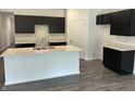Modern kitchen featuring a large island with a white countertop and dark cabinetry at 3933 Donaldson Creek Ct, Clayton, IN 46118