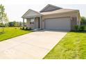 Well-manicured lawn leads to a charming home with a gray garage door and matching trim at 3949 Donaldson Creek Ct, Clayton, IN 46118
