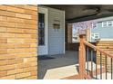 Covered front porch with brick pillars, ceiling fan, black security door, and house number 5970 at 3970 Broadway St, Indianapolis, IN 46205