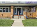 Inviting front porch with brick columns, security door, and professionally landscaped yard showcasing the home's curb appeal at 3970 Broadway St, Indianapolis, IN 46205
