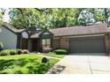 A single-story home with mature landscaping and a two-car attached garage at 5329 Hawks Point Rd, Indianapolis, IN 46226