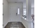 Inviting entryway featuring hardwood floors, white trim, and an attractive front door with a security system at 5524 Coventry Park Way, Indianapolis, IN 46237