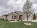 Exterior view of a well-kept home with a blossoming tree in the front yard at 5524 Coventry Park Way, Indianapolis, IN 46237