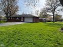 Well-maintained single-story brick home with a green lawn and attached garage, offering suburban living at 7002 Mclain Dr, Indianapolis, IN 46217