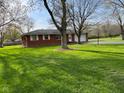 Single-story brick home on a verdant lot, showcasing its exterior and landscaping at 7002 Mclain Dr, Indianapolis, IN 46217