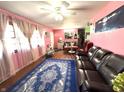 Inviting living room featuring hardwood floors, a ceiling fan, and natural light from the windows with sheer curtains at 709 Braugham Rd, Indianapolis, IN 46227