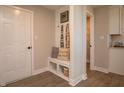Well-organized mudroom features built-in bench, coat hooks, decorative pillows, and easy access to storage at 7282 Portico Ln, McCordsville, IN 46055
