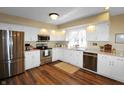 Bright kitchen featuring stainless steel appliances, white cabinets, granite countertops, and hardwood floors at 7608 Andrew Turn, Plainfield, IN 46168